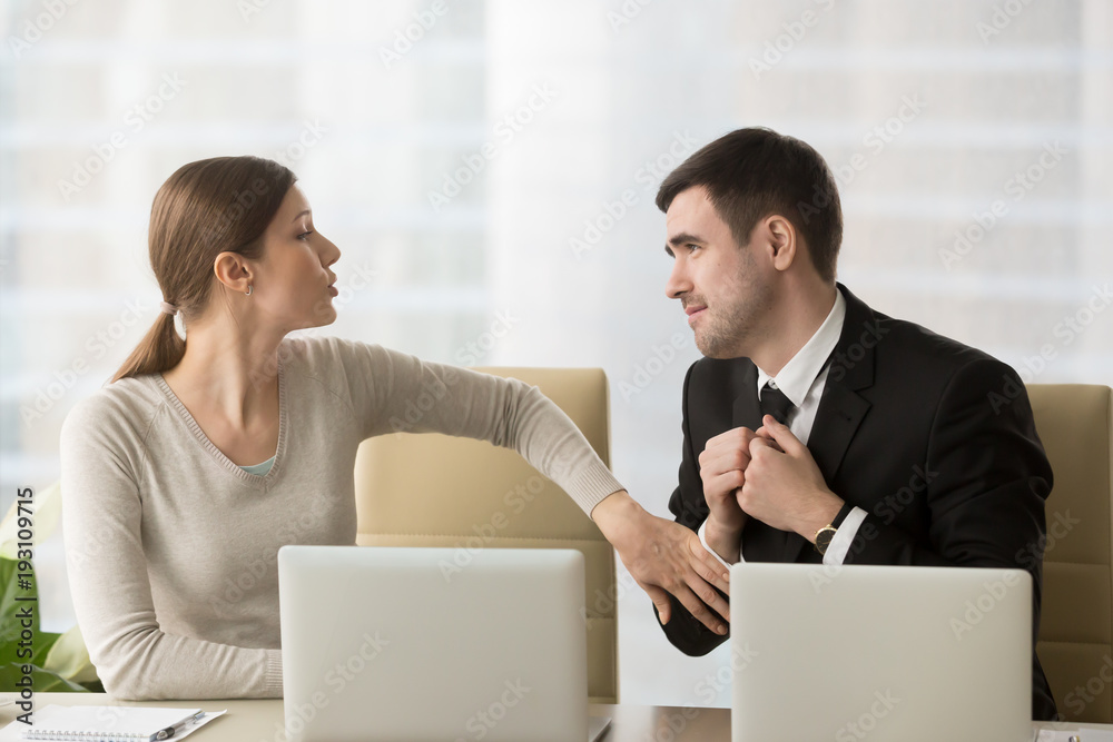 Obraz premium Man with deliberately sad facial expression asking female coworker to help with difficult project to leave work earlier, inviting colleague to date. Businesswoman refuses in request of foolish admirer