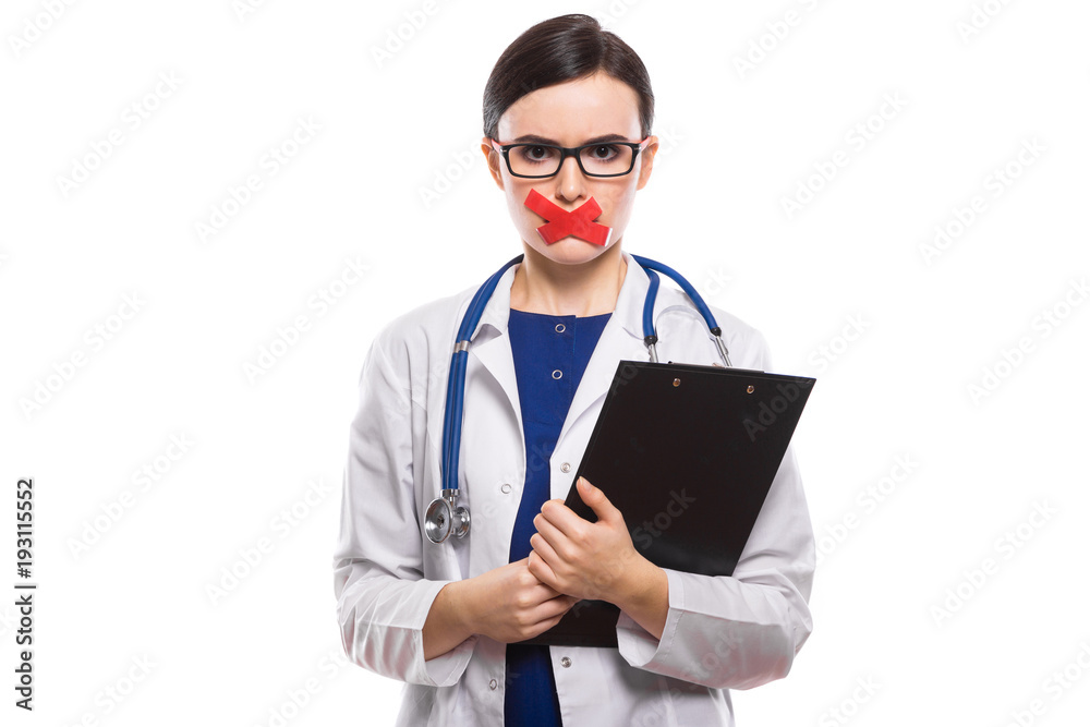 Young woman doctor with stethoscope holding clipboard in her hands with taped lips in white uniform on white background Young woman doctor with stethoscope holding clipboard in her hands with taped lips in white uniform on white background