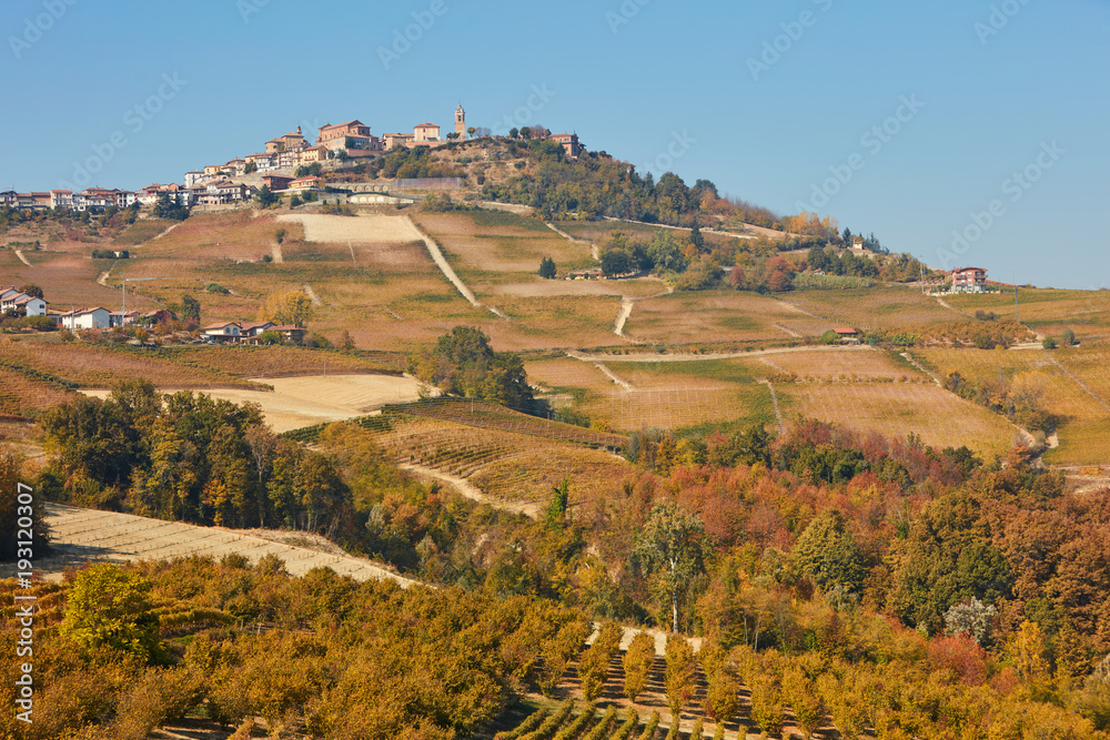 La Morra town on hill surrounded by fields, vineyards, woods in a sunny fall day in Piedmont, Italy