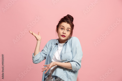Beautiful woman looking suprised and bewildered isolated on pink