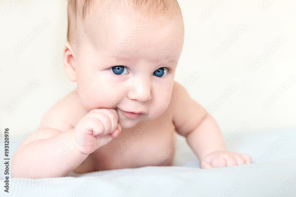 Portrait of small infant kid boy. Child holding head with fist. Baby with confident pensive sight. Serious emotion or expresssion on face. Selective focus Portrait of small infant kid boy. Child holding head with fist. Baby with confident pensive sight. Serious emotion or expresssion on face. Selective focus