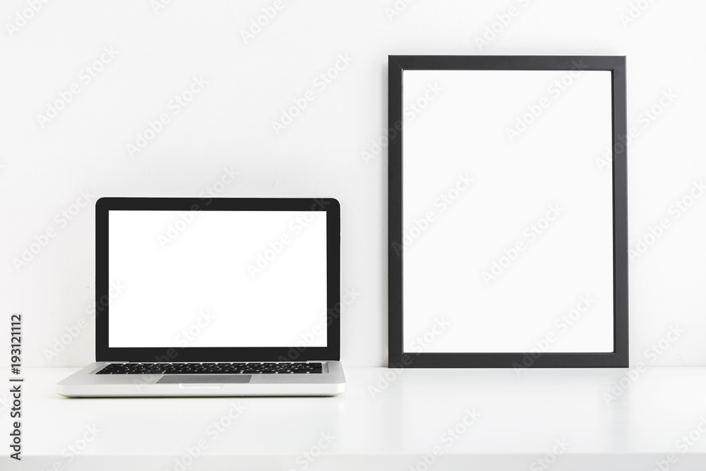 Laptop and a poster frame. Black and white color mock up. Laptop and a poster frame. Black and white color mock up.