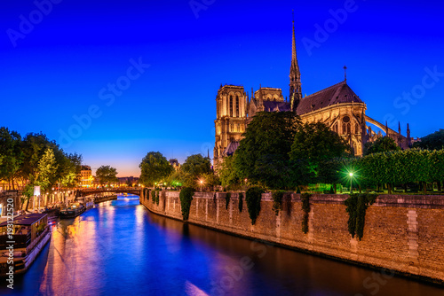 Night view of Cathedral Notre Dame de Paris and river Seine in Paris, France