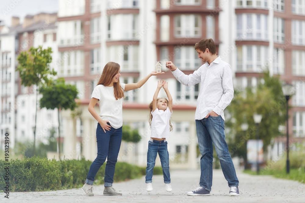 Happy family in front of new apartment building Happy family in front of new apartment building