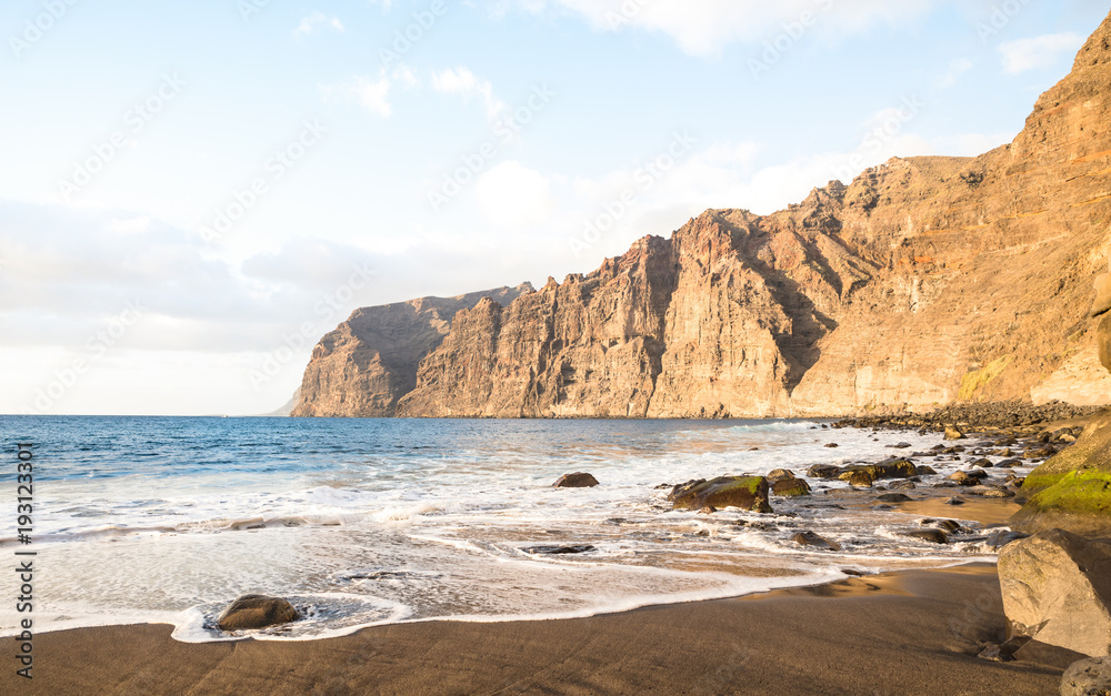 Desert solitary beach in Tenerife with Los Gigantes cliffs on background - Travel concept with nature wonder landscape in Canary islands Spain - Bright warm afternoon filtered color tones