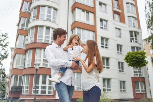 Happy family in front of new apartment building