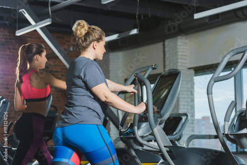 sporty and overweight  women training on treadmills at gym