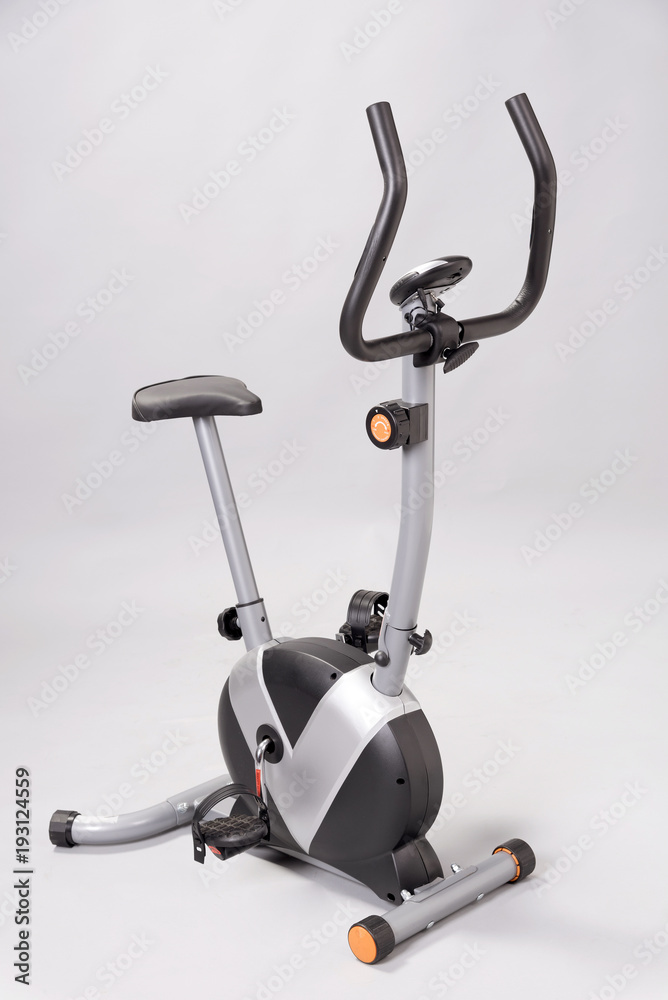 An exercise bicycle against a plain grey background An exercise bicycle against a plain grey background