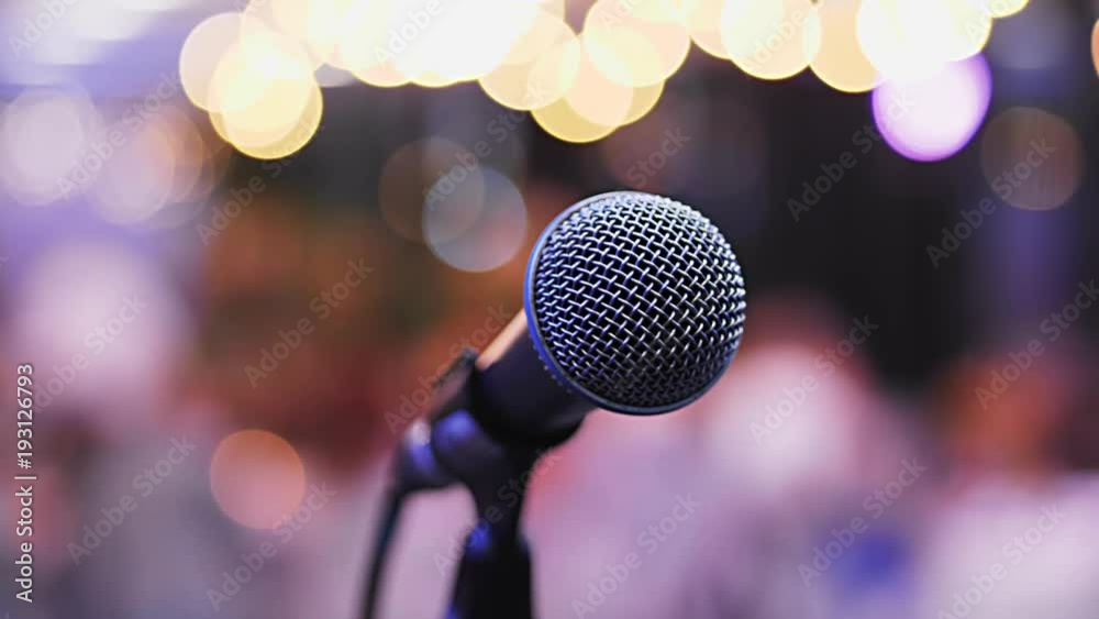 Microphone on the Stand is Standing on the Stage, Close-Up Microphone on the Background of the Auditorium, Spotlight