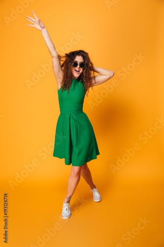 Excited young woman wearing sunglasses.