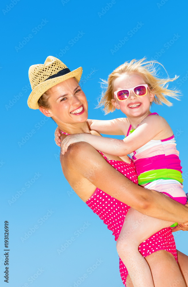 smiling modern mother and child on seashore