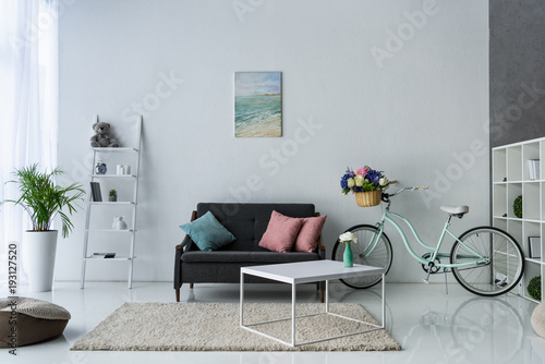 view of stylish living room with retro bicycle, coffee table and sofa