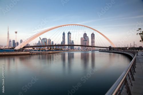 DUBAI, UAE - FEBRUARY 2018: Colorful sunset over Dubai Downtown skyscrapers and the newly built Tolerance bridge as viewed from the Dubai water canal. © Melinda Nagy