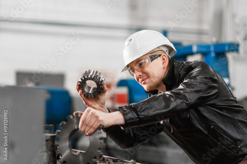 factory engineer checks the quality of the manufactured part photo