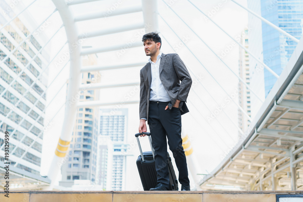 Business man walking at outdoors with luggage in the routine of working with determination and confidence. concept of business trip travel and transportation. Business man walking at outdoors with luggage in the routine of working with determination and confidence. concept of business trip travel and transportation.