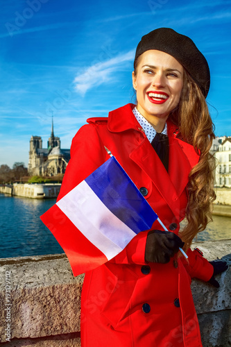 smiling woman in Paris with French flag looking into the distance