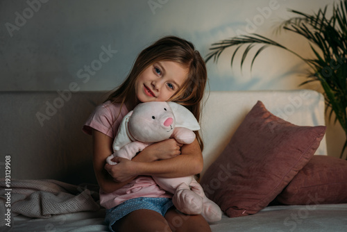 portrait of cute kid with toy resting on sofa