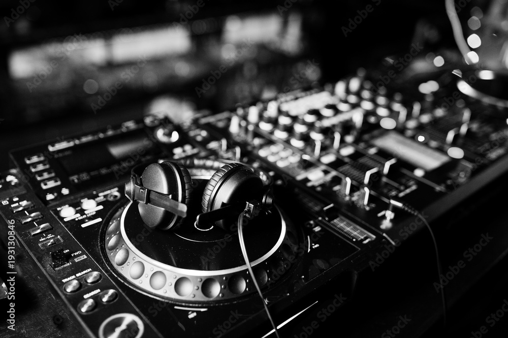 Naklejka premium DJ kręci miksowaniem i scratchowaniem ścieżek na stroboskopie. Koncepcja życia klubu Dj Music.