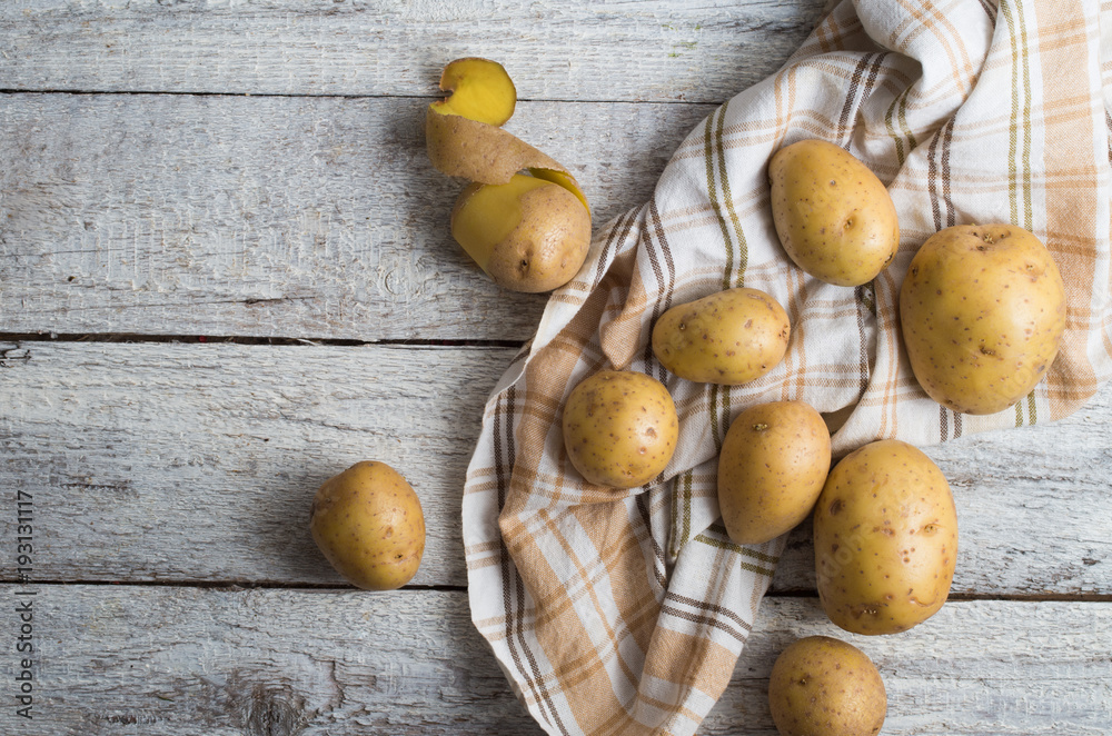 Fresh potatoes on an old wooden table Fresh potatoes on an old wooden table