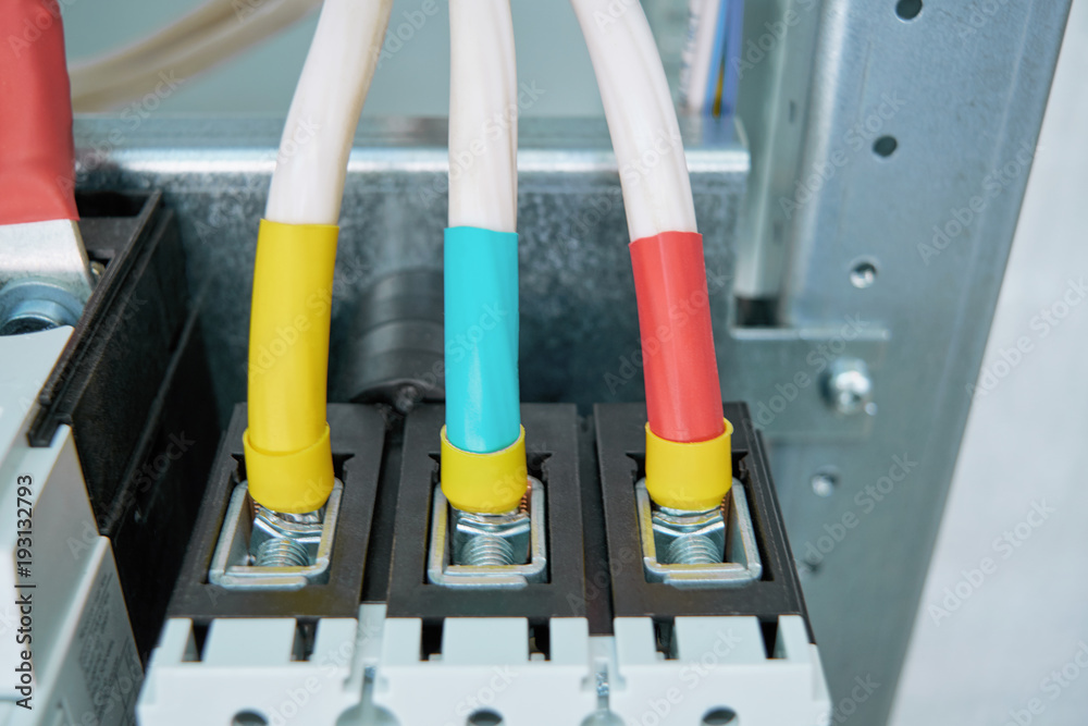 Electrical wires or cables are connected to the circuit breaker. The wires or cables are connected using clamp clamps. The wires are marked red, green and yellow. Electrical wires or cables are connected to the circuit breaker. The wires or cables are connected using clamp clamps. The wires are marked red, green and yellow.