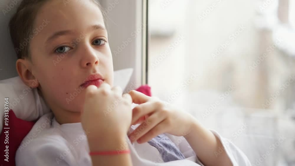 Boy sitting near on window sill measure the temperature Boy sitting near on window sill measure the temperature