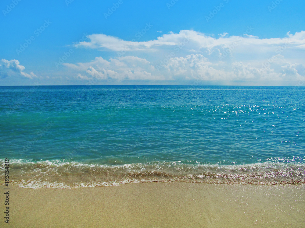 Sand beach and water in summer sunny day.
Beautiful ocean view with a small smooth waves on the beach in Miami, Florida, USA.Travel vacation concept.