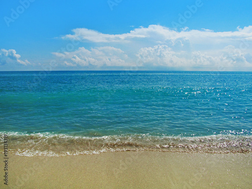 Sand beach and water in summer sunny day.  Beautiful ocean view with a small smooth waves on the beach in Miami  Florida  USA.Travel vacation concept.