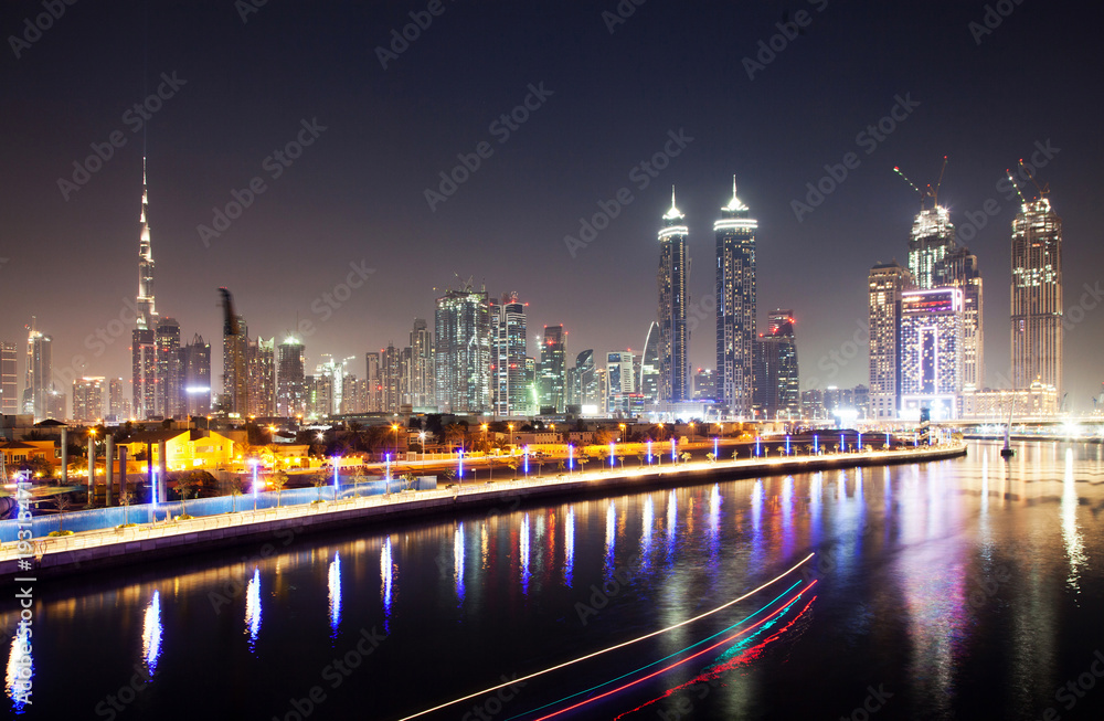 DUBAI, UAE - FEBRUARY 2018: Colorful sunset over Dubai Downtown skyscrapers and the newly built Tolerance bridge as viewed from the Dubai water canal.