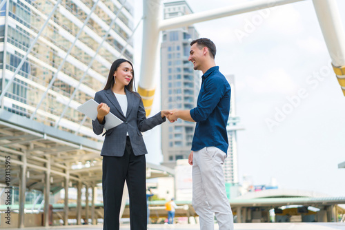 Beautiful asian businesswoman shaking hands with handsome man for success business solution. concept of communication, negotiation and business together.