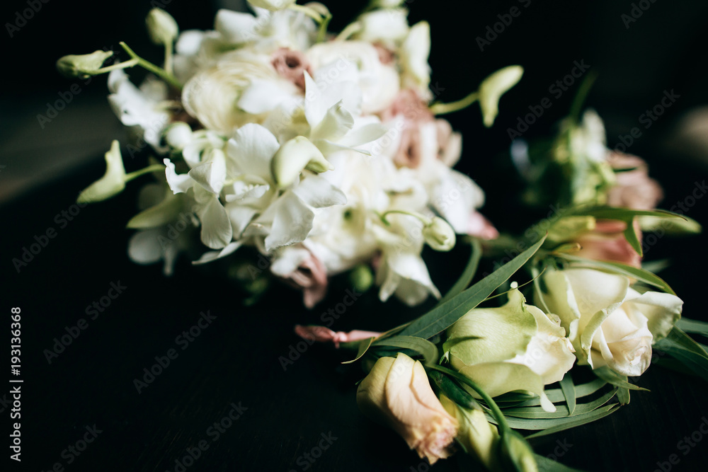 A beautiful wedding bouquet of brides from white flowers on a dark wooden background A beautiful wedding bouquet of brides from white flowers on a dark wooden background