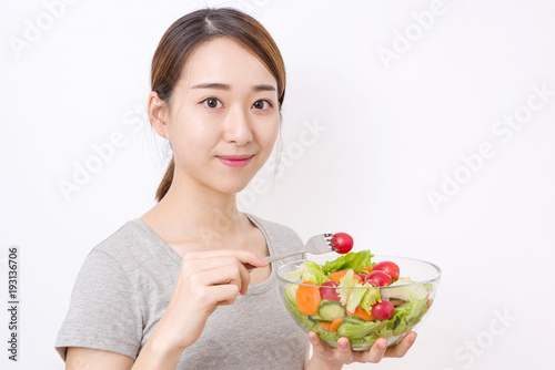 Healthy lifestyle concept. Young woman eating salad.