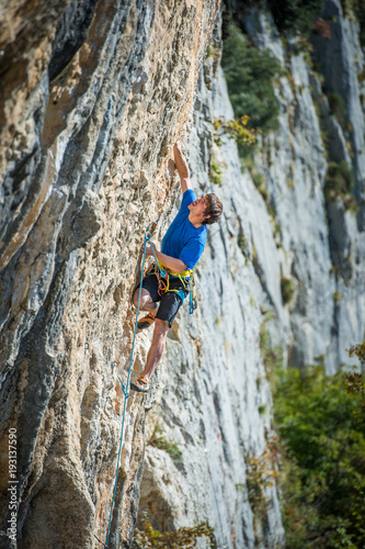 Young man climbing extreme hard route on limestone rocks