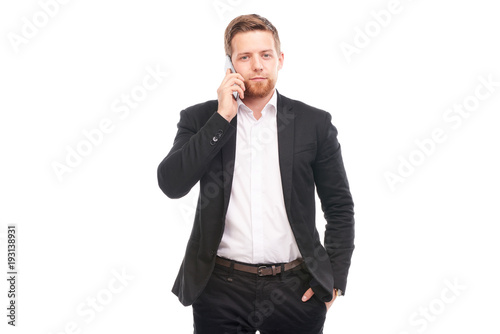 Portrait of young businessman with mobile phone on white background