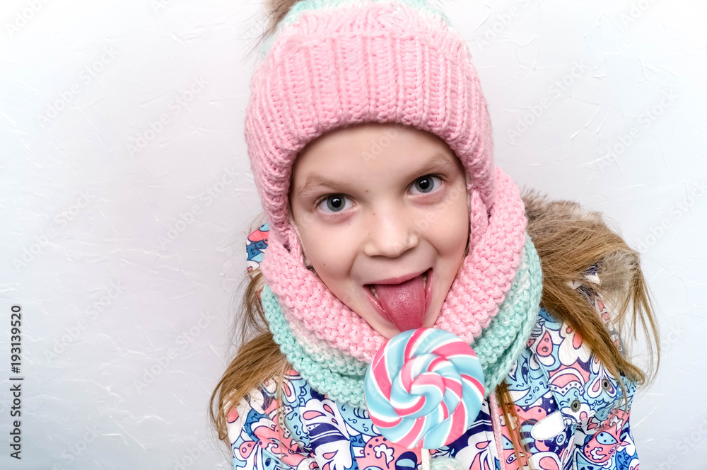 smiling girl with lollipop in winter clothes smiling girl with lollipop in winter clothes