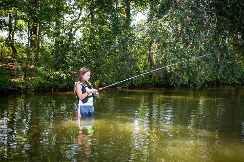 Young teenage girl fishing in the water