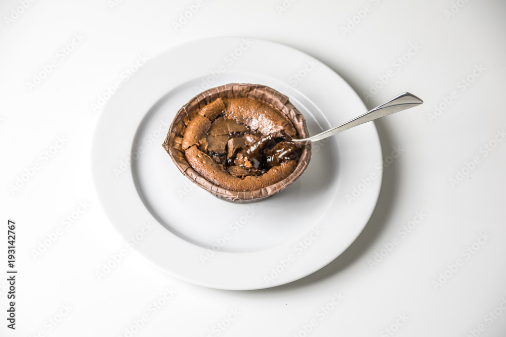 Schokoladenkuchen mit heißem Schokoladenkern - Dessert auf Teller mit Löffel, Vogelperspektive Schokoladenkuchen mit heißem Schokoladenkern - Dessert auf Teller mit Löffel, Vogelperspektive