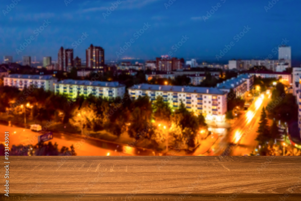 Empty wooden table with blurred background of night city. Can be used for display or montage products