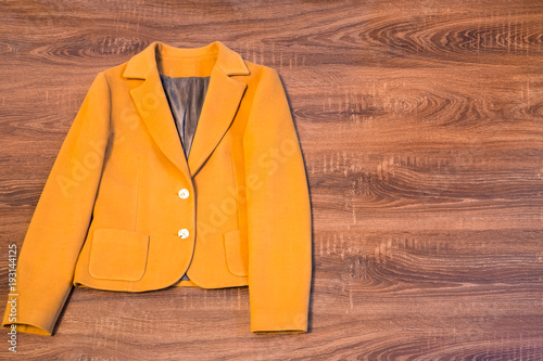 Stylish female blazer on wooden background
