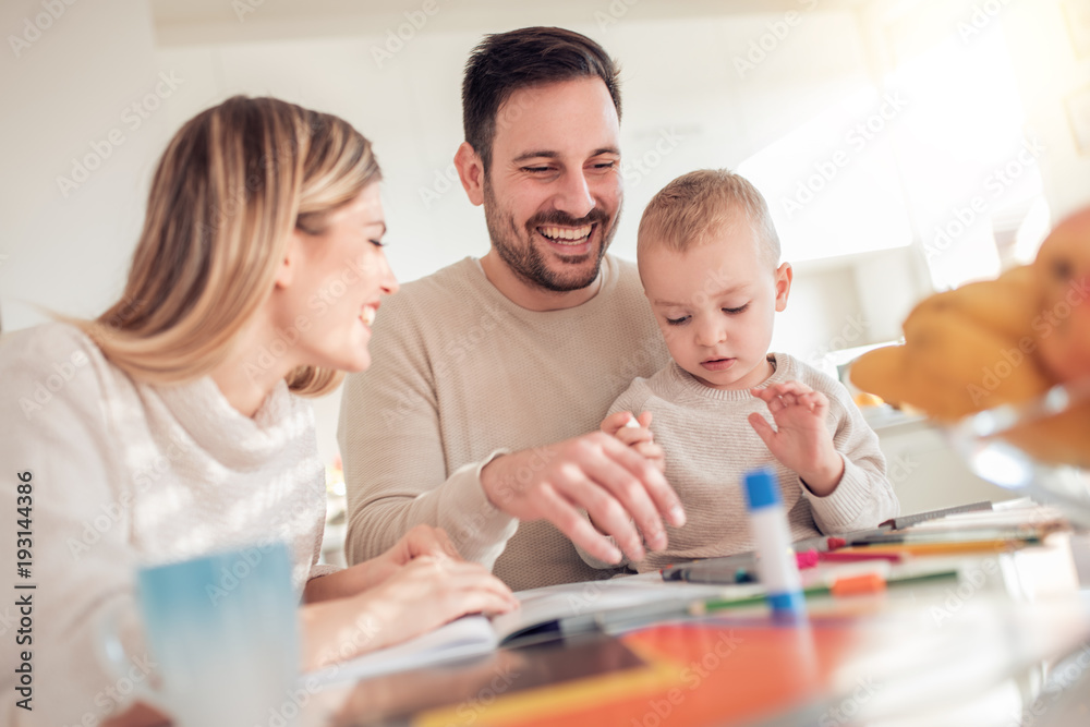 Smiling family drawing together at home Smiling family drawing together at home