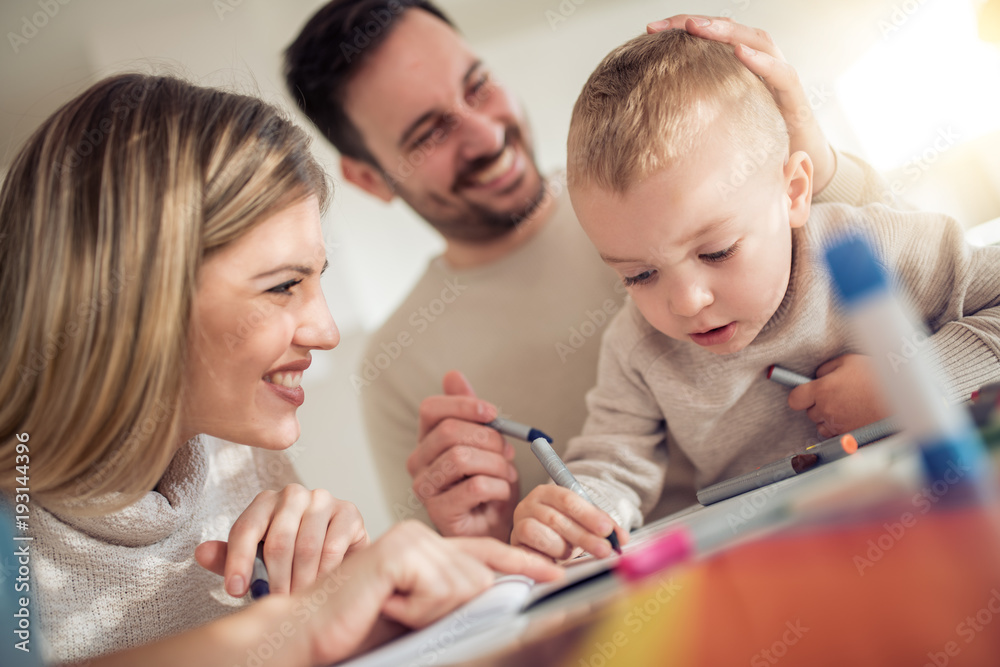 Smiling family drawing together at home Smiling family drawing together at home