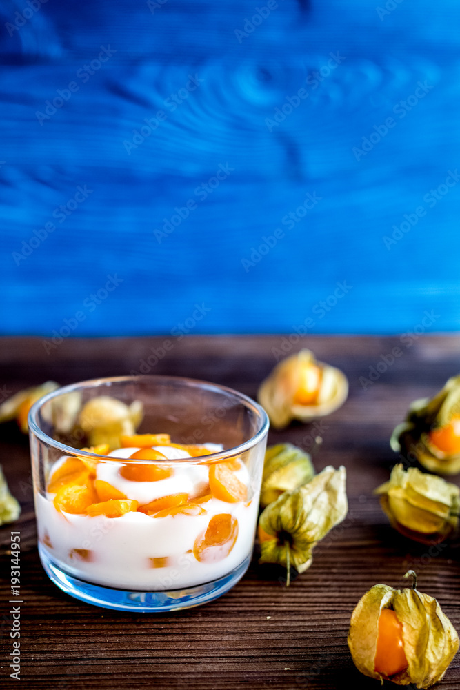 yogurt with physalis on wooden background