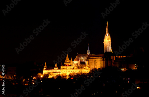 Floodlit towers and spires of Fisherman's Bastion and Matthias Church rise to black sky illuminated by exterior facade lighting, Buda Castle Hill Halaszbastya Matyas Templom Budapest Hungary Europe