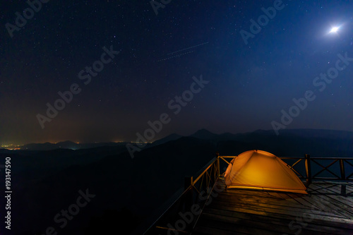 Lonely camping on the mountain under the stars and blue sky.