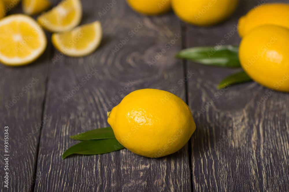 Juicy ripe lemons are scattered on wooden surface