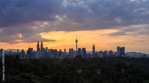 Photography Beautiful aerial view of Kuala Lumpur city skyline, skyscraper during sunrise with dramatic sky, clouds and sun rays