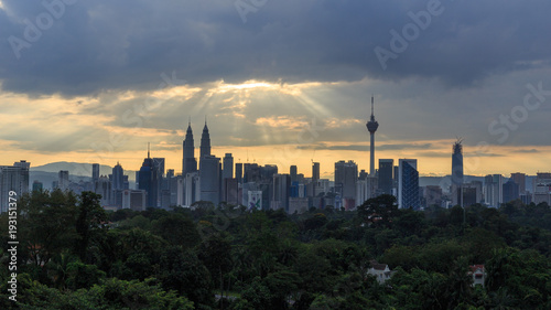 Photography Beautiful aerial view of Kuala Lumpur city skyline, skyscraper during sunrise with dramatic sky, clouds and sun rays