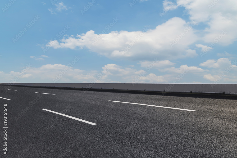 Asphalt pavements and square floor tiles under the blue sky and white clouds Asphalt pavements and square floor tiles under the blue sky and white clouds