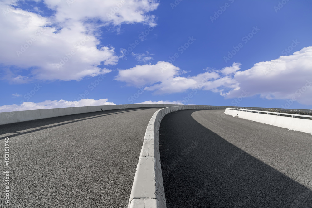 Asphalt pavements and square floor tiles under the blue sky and white clouds Asphalt pavements and square floor tiles under the blue sky and white clouds