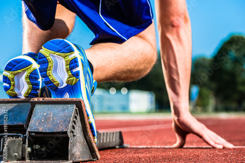 Fototapeta Naklejka Na Ścianę i Meble -  Runner before start signal on starting block of sprint track in sport stadium