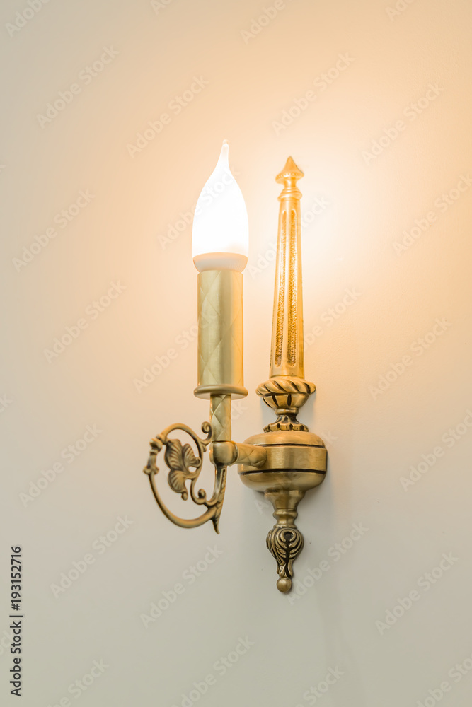 brass sconce with lighting bulb on white wall brass sconce with lighting bulb on white wall